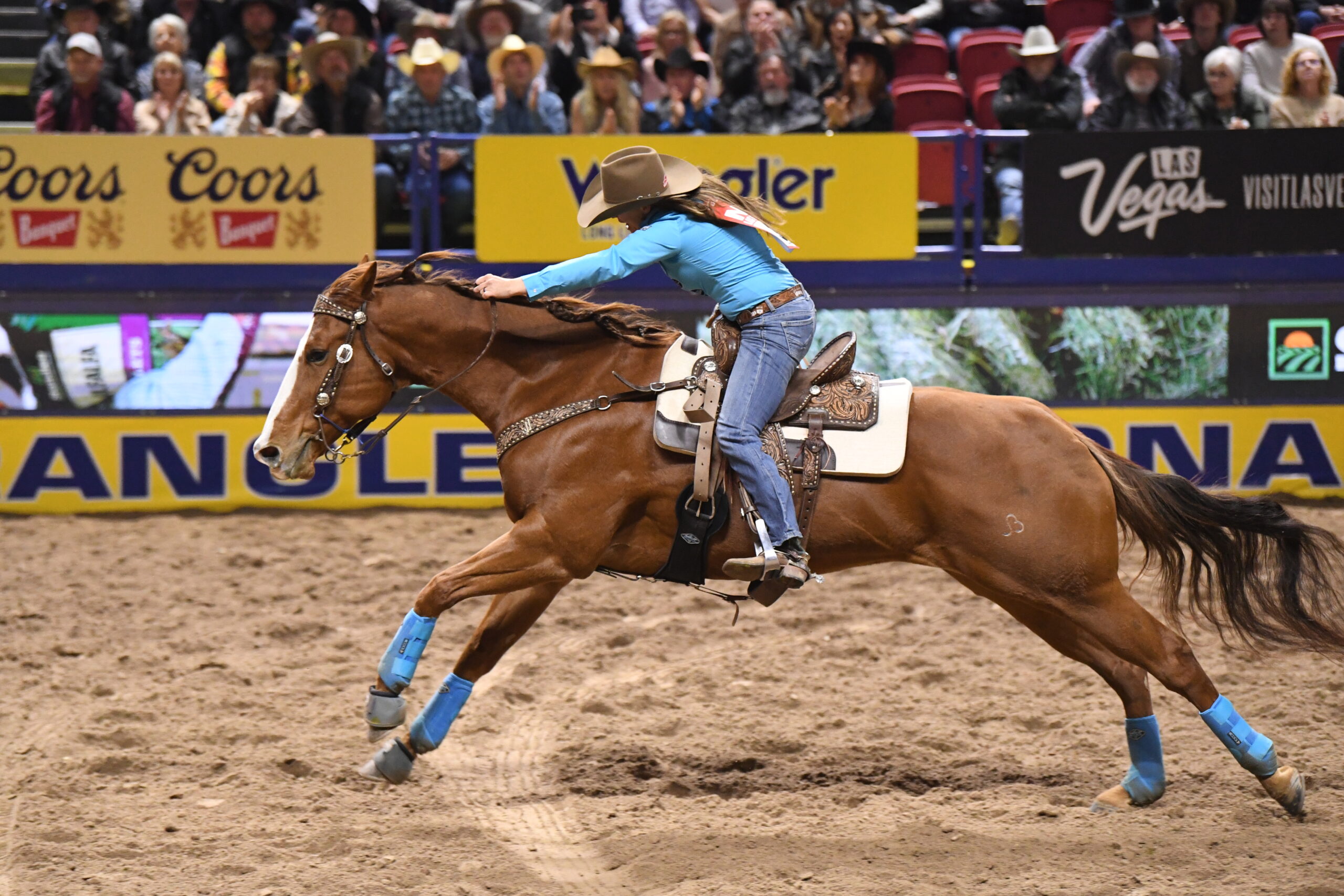Barrel racer and horse competing at a PRCA rodeo, chasing points toward the National Finals Rodeo